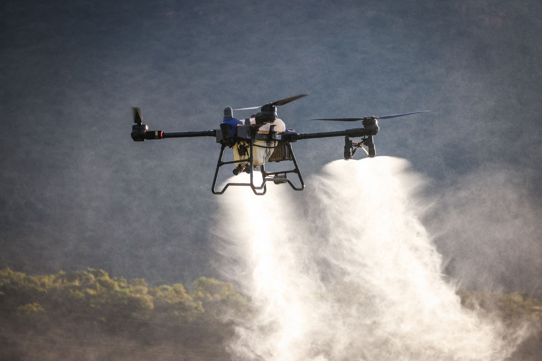 Agricultural drone applying a precision spray over crops